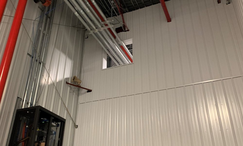 Looking up at pipe sections of new warehouse partition