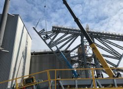 material processing site under construction with crane lift