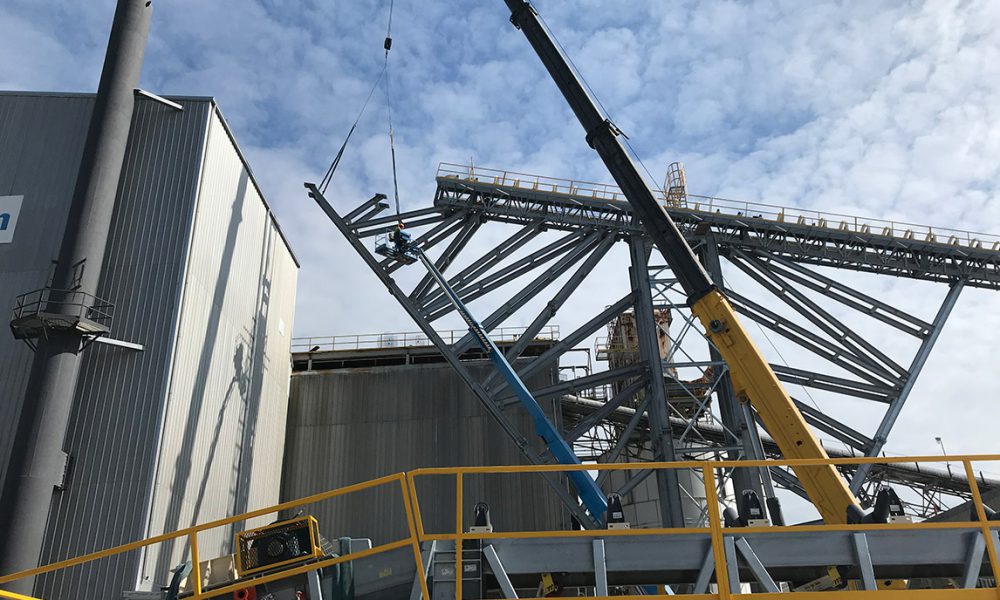 material processing site under construction with crane lift